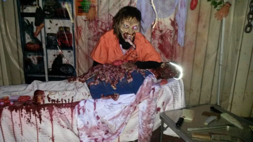 Party Dj Services and a zombie prop mannequin on a table, surrounded by Halloween decorations 