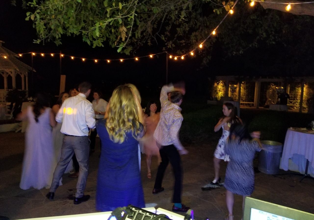 the wedding guests dancing, enjoying the outdoor, night wedding reception.