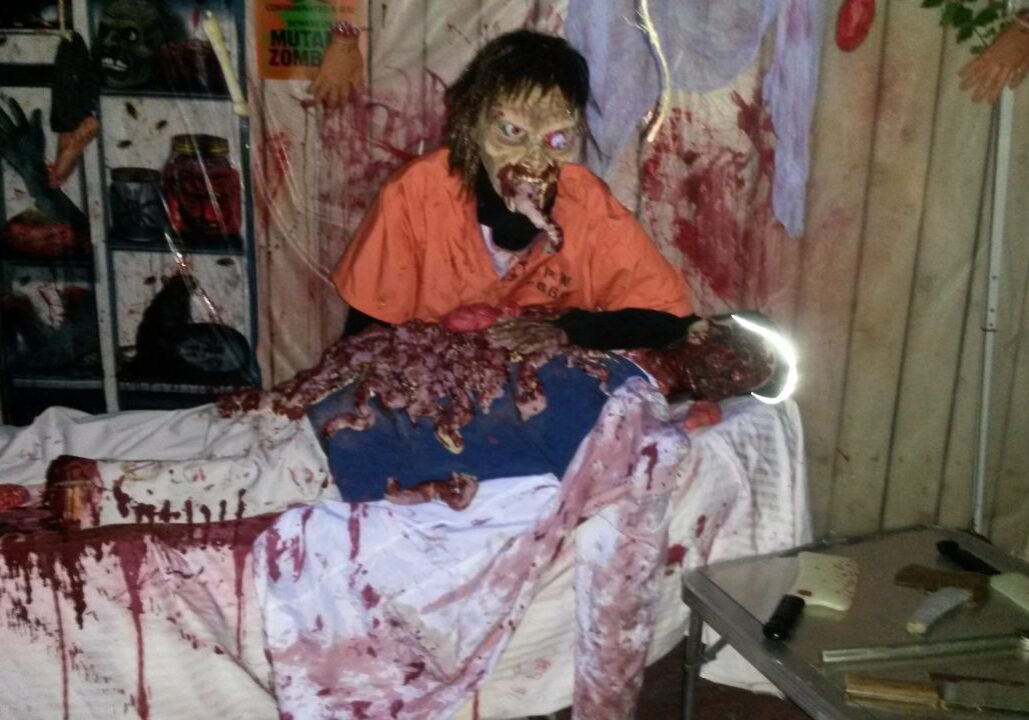 Party Dj Services and a zombie prop mannequin on a table, surrounded by Halloween decorations